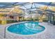 Kidney-shaped swimming pool with screened enclosure at 1465 Riviera Dr, Kissimmee, FL 34744