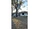 Side view of a single-story house with mature trees at 1750 12Th St, Clermont, FL 34711