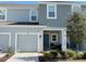 Two-story townhome with gray exterior, two-car garage, and front porch at 1861 Roosevelt Pl, St Cloud, FL 34769