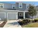 Two-story townhome with gray exterior, two-car garage, and front porch at 1861 Roosevelt Pl, St Cloud, FL 34769