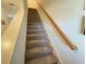 Carpeted staircase with wooden handrail leading to the upper level at 1861 Roosevelt Pl, St Cloud, FL 34769
