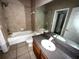 Second bathroom with tub, toilet and vanity with dark countertop at 2642 Rutledge Ct, Winter Haven, FL 33884