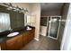 Main bathroom with double vanity, dark countertop, and a shower/tub combo at 2642 Rutledge Ct, Winter Haven, FL 33884