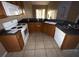 L-shaped kitchen with dark countertops, wood cabinets, and standard appliances at 2642 Rutledge Ct, Winter Haven, FL 33884