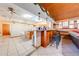 Kitchen with breakfast bar, wood cabinets and view into living room at 2801 S Granada Blvd, Kissimmee, FL 34746