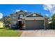 Two-story house with a large garage and well-manicured lawn at 2906 Vista Ct, Kissimmee, FL 34744