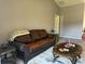 Living room features a brown leather couch and coffee table at 308 Coventry Estates Blvd, Deltona, FL 32725