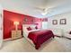 King bed, red accent wall, and ceiling fan at 4191 Oaktree Drive, Davenport, FL 33837