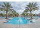 Large community pool with palm trees and lounge chairs at 4191 Oaktree Drive, Davenport, FL 33837