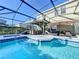 Inviting pool and spa with covered patio, outdoor seating, and lush landscaping at 4191 Oaktree Drive, Davenport, FL 33837