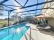 Inviting swimming pool with screened enclosure and lounge chairs at 4191 Oaktree Drive, Davenport, FL 33837
