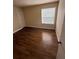 Bright bedroom featuring wood-look floors and a window with blinds at 4728 Walden Cir # 37, Orlando, FL 32811
