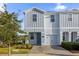 Two-story townhome with gray siding, two-car garage, and a landscaped front yard at 4858 Tribute Trl, Kissimmee, FL 34746