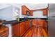 Modern kitchen with dark wood cabinets, granite counters, and stainless steel appliances at 4860 Conway Rd # 56, Orlando, FL 32812