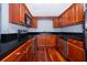 Modern kitchen with dark wood cabinets, granite countertops, and stainless steel appliances at 4860 Conway Rd # 56, Orlando, FL 32812