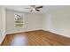 Bright bedroom with wood-look flooring, large window, and ceiling fan at 4950 Nova Ave, St Cloud, FL 34773