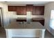 Spacious kitchen with dark brown cabinets and granite countertops at 640 Spanish Pine Rd, Davenport, FL 33837