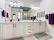 Double vanity bathroom with light cabinets and walk-in shower at 681 San Joaquin Rd, Poinciana, FL 34759
