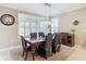 Bright dining room features a wood table, wicker chairs, and plantation shutters at 681 San Joaquin Rd, Poinciana, FL 34759