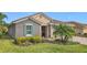 Single-story home with gray exterior, teal shutters, and a stone accent wall at 681 San Joaquin Rd, Poinciana, FL 34759