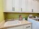 Laundry room featuring granite countertop and white cabinets at 681 San Joaquin Rd, Poinciana, FL 34759