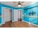 Blue bedroom with wood floors, ceiling fan, and plenty of closet space at 8 Catalina Ct, Kissimmee, FL 34758