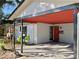 Inviting covered entryway with a red front door and landscaping at 916 S Park Ct, Kissimmee, FL 34741