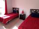 Twin bedroom with red bedding and natural light at 922 Sandy Ridge Drive Dr, Davenport, FL 33896