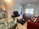 Living area with red sofa, glass dining table and kitchen access at 922 Sandy Ridge Drive Dr, Davenport, FL 33896