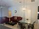 Living room features a red couch, a glass dining table, and neutral walls at 922 Sandy Ridge Drive Dr, Davenport, FL 33896