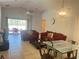 Living room with glass-top dining table, red sofa, and access to patio at 922 Sandy Ridge Drive Dr, Davenport, FL 33896