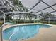 Relaxing kidney-shaped pool with screened enclosure and tranquil backyard view at 1678 Waterview Loop, Haines City, FL 33844