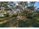Backyard features a large, grassy area shaded by mature oak trees with Spanish moss at 2828 Sequoyah Dr, Haines City, FL 33844