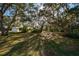 Backyard features a large, grassy area shaded by mature oak trees with Spanish moss at 2828 Sequoyah Dr, Haines City, FL 33844