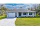 Single-story home with gray roof, white walls, and a paved driveway at 2828 Sequoyah Dr, Haines City, FL 33844