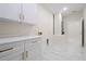 Bright laundry room with white cabinets and marble-look floors at 2828 Sequoyah Dr, Haines City, FL 33844