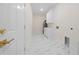 Laundry room with white cabinets, marble-look floors, and a water heater at 2828 Sequoyah Dr, Haines City, FL 33844