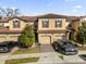 Two-story townhome with tile roof, two-car garage, and landscaping at 8121 Roseville Blvd, Davenport, FL 33896
