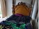 Bedroom with wooden bed frame and dark bedding at 10407 Sw 85Th Ct, Ocala, FL 34481