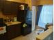 Kitchen with dark cabinets and black refrigerator at 10407 Sw 85Th Ct, Ocala, FL 34481