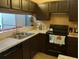Kitchen with dark brown cabinets, stainless steel appliances, and a double sink at 10407 Sw 85Th Ct, Ocala, FL 34481