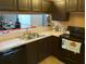 Kitchen with dark brown cabinets, stainless steel appliances, and a double sink at 10407 Sw 85Th Ct, Ocala, FL 34481