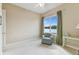 Bedroom with lake view, armchair, and neutral color palette at 256 New River Dr, Poinciana, FL 34759