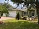 Green house with brick driveway, landscaping, and two-car garage at 2605 Coldstream Ct, Kissimmee, FL 34743