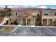 Two-story townhouses with Spanish-style architecture, featuring light-colored exteriors and lush landscaping at 2627 Bugatti Ct, Kissimmee, FL 34746
