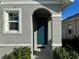 Front entrance with arched entryway and teal door at 2843 Turnstone Run, Harmony, FL 34773