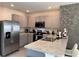 Modern kitchen with stainless steel appliances and gray cabinets at 2843 Turnstone Run, Harmony, FL 34773