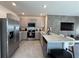 Open concept kitchen with breakfast bar and stainless steel appliances at 2843 Turnstone Run, Harmony, FL 34773