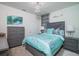 Light and bright bedroom with gray dresser and teal bedding at 2937 Hooded Crane Cv, Harmony, FL 34773