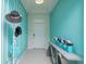 Stylish entryway with teal walls and modern decor at 2937 Hooded Crane Cv, Harmony, FL 34773